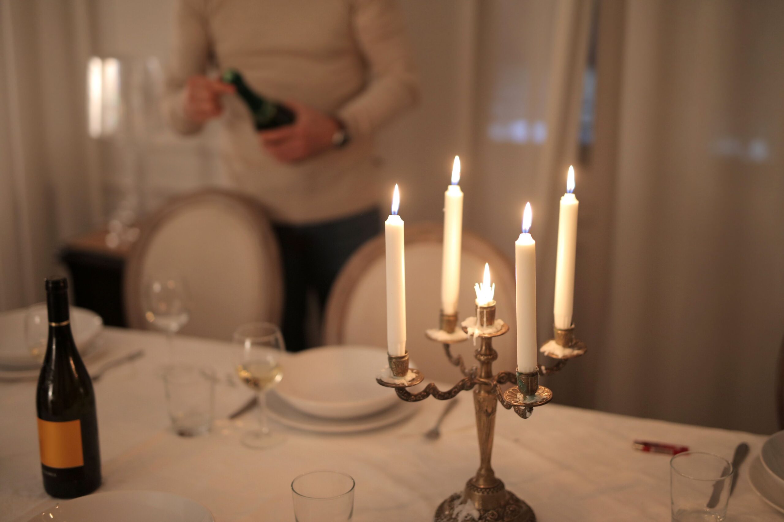 How To Master Lighting For A Cozy Bedroom A refined candlelit dinner table setup with wine, perfect for intimate gatherings.
